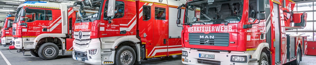 Reihen von roten Feuerwehrfahrzeugen, die nebeneinander stehen.